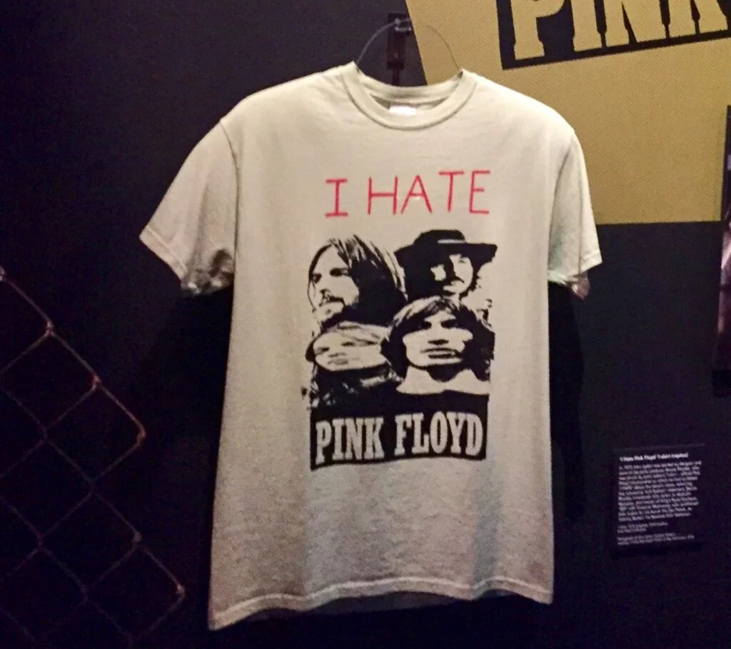 Weisses T-Shirt mit Aufschrift "I HATE PINK FLOYD" und den Köpfen der vier Bandmitglieder von Pink Floyd. 