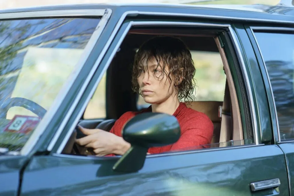 Eine Frau mit nassen Haaren sitzt am Steuer eines Autos.