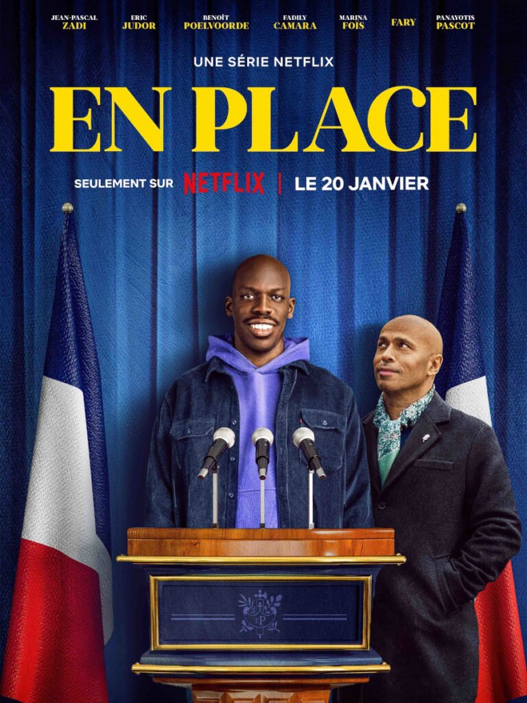 Serienposter mit Schriftzug. Ein Mann steht an einem Rednerpult umrahmt von zwei französischen Flaggen. Neben ihm steht ein weiterer Mann.