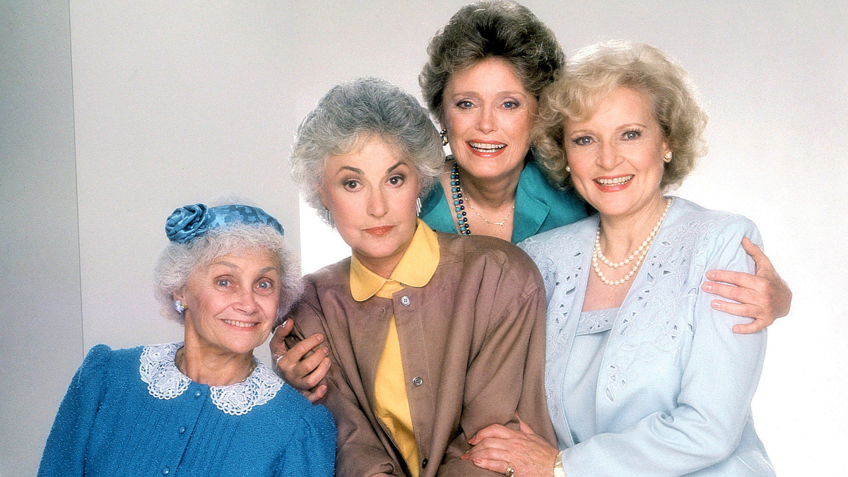Vier ältere Frauen in Kostümen stehen nebeneinander. 