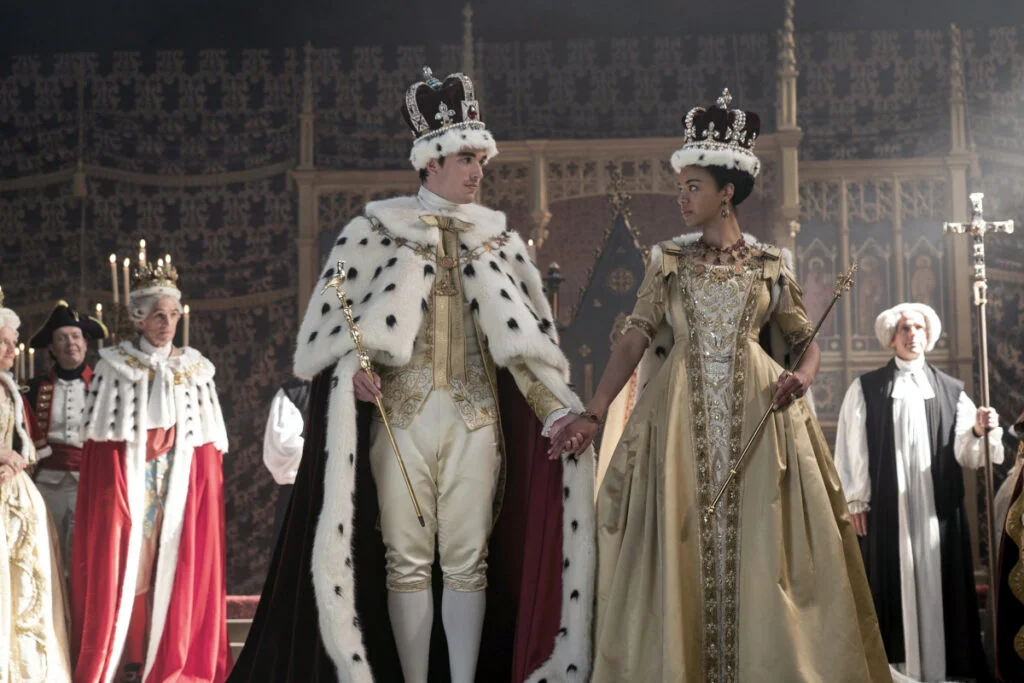 Das Königspaar mit Kronen in prunkvollen Kleidern.