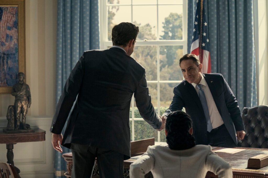 Zwei Männer schütteln sich die Hände im Oval Office. Eine Frau sitzt noch im Sessel vor dem Pult des Präsidenten.