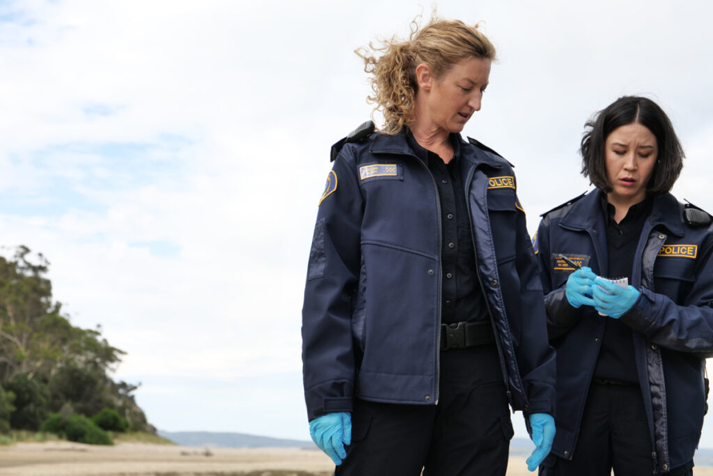 Zwei Frauen in Polizeiuniform stehen an einem Strand.