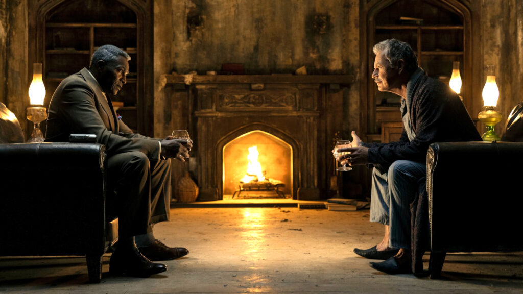 Zwei ältere Männer sitzen sich auf Sesseln gegenüber. Im Hintergrund ein Kaminfeuer.