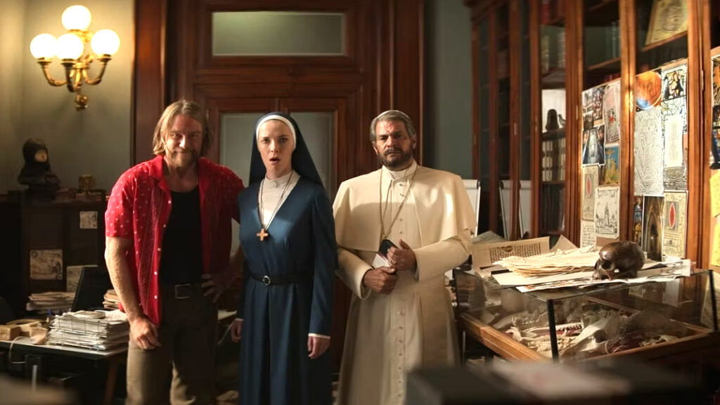 Eine Nonne umrahmt von einem Geistlichen in weissem Gewand, der Papst, und einem Mann im rotem Hemd.