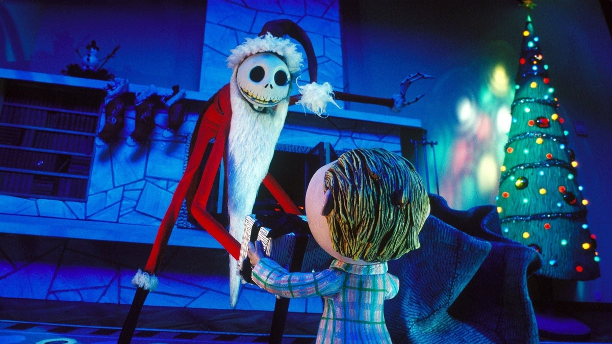 Eine Weihnachtsmannpuppe, die als Kopf einen Schädel hat, überreicht einer anderen Puppe ein Geschenk. © TMDB