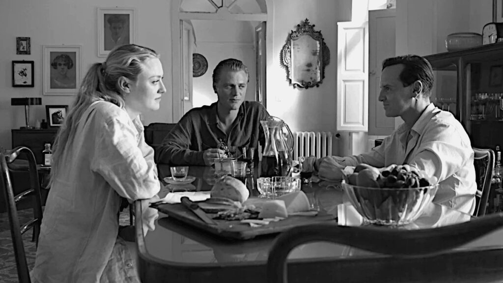 Eine Frau und zwei Männer an einem Tisch mit Essen darauf. 