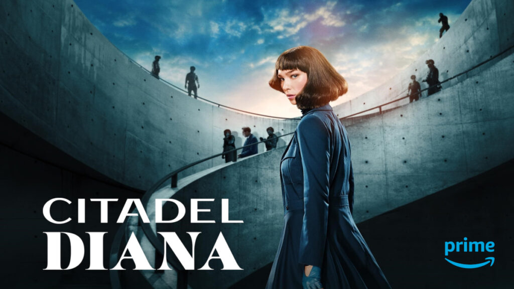 Serienposter mit Schriftzug. Eine junge Frau in einem langen Mantel in Seitenansicht. Sie hat den Kopf zur Kamera gewendet. Im Hintergrund eine Rundtreppe aus Beton, auf der bewaffnete und maskierte Personen zu sehen sind.