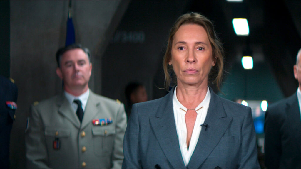 Eine Frau im Hintergrund ein Mann in Uniform.