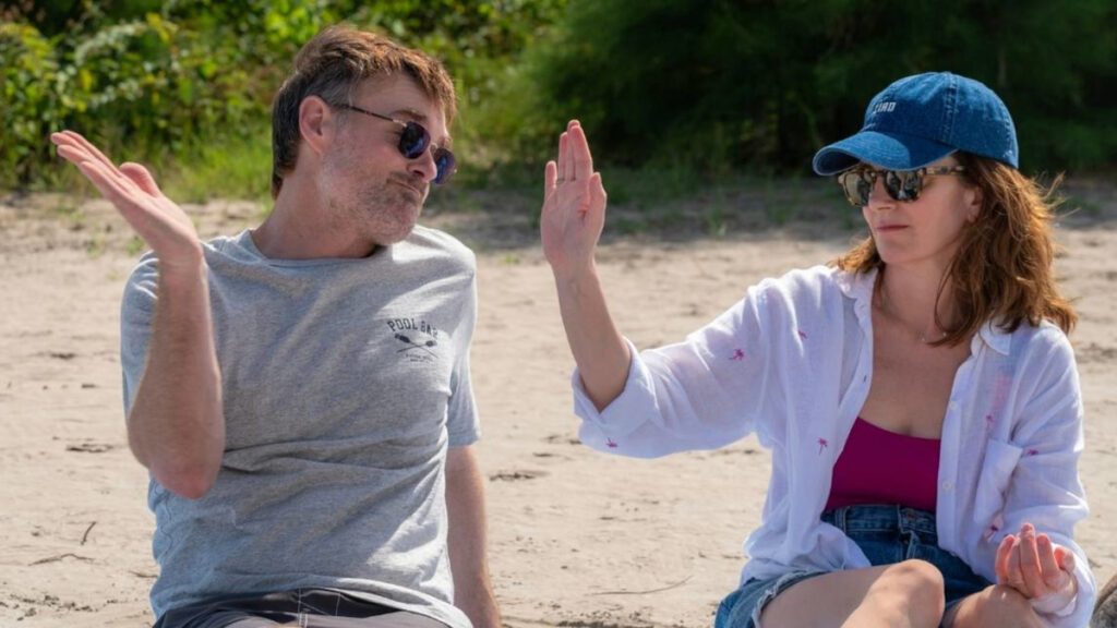 Ein Mann und eine Frau am Strand klatschen sich ab.