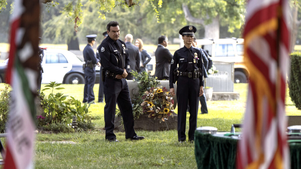 Ein Mann und eine Frau in Polizeiuniform auf einem Friedhof.