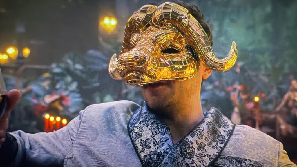 Ein Mann mit einer goldenen Büffelmaske auf dem Gesicht.