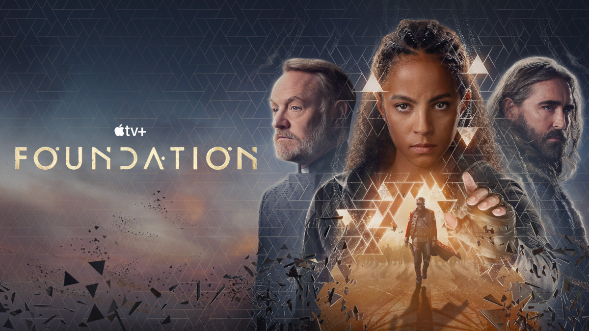 Drei Personen sind prominent zu sehen, umgeben von geometrischen Mustern. Links steht der Titel «Foundation» und das Logo von Apple TV+. Im Vordergrund geht eine Figur auf den Betrachter zu, inmitten eines dynamischen Lichteffekts. Die Szenerie wirkt futuristisch und geheimnisvoll.