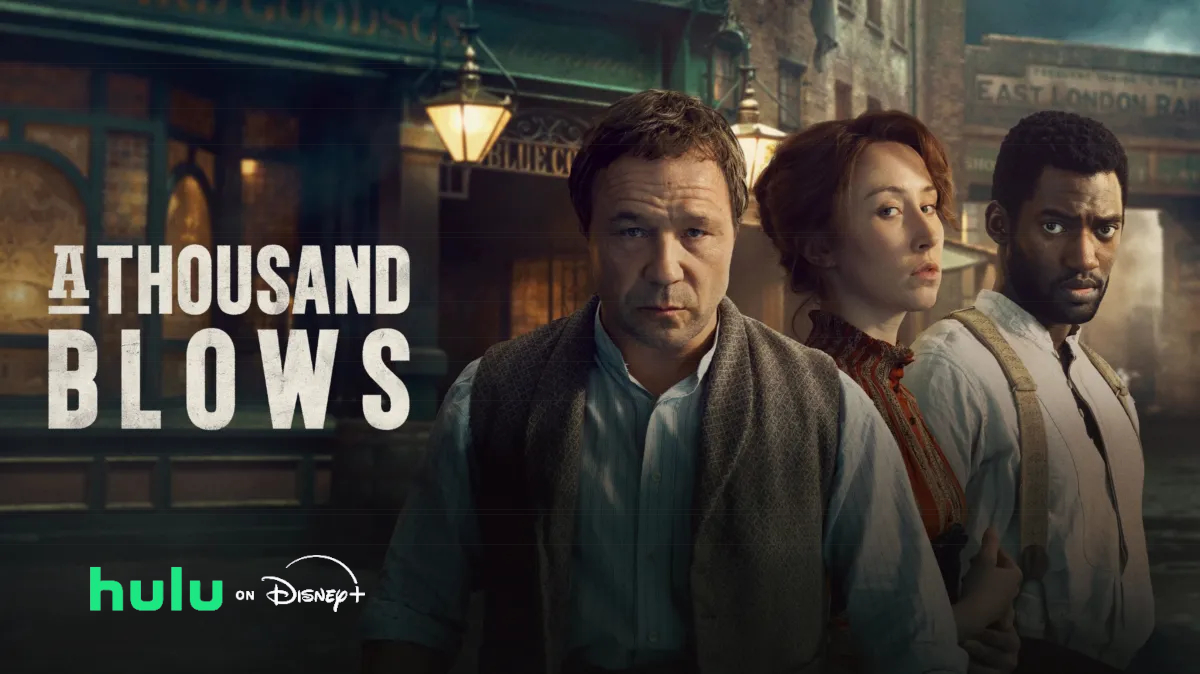 Drei Personen stehen vor einem viktorianischen Gebäude. Links der Schriftzug «A Thousand Blows». Darunter die Logos von «hulu» und «Disney+». Die Figuren wirken ernst und fokussiert, während sie in unterschiedlichen Richtungen blicken. Die Szenerie strahlt eine historische, düstere Atmosphäre aus.