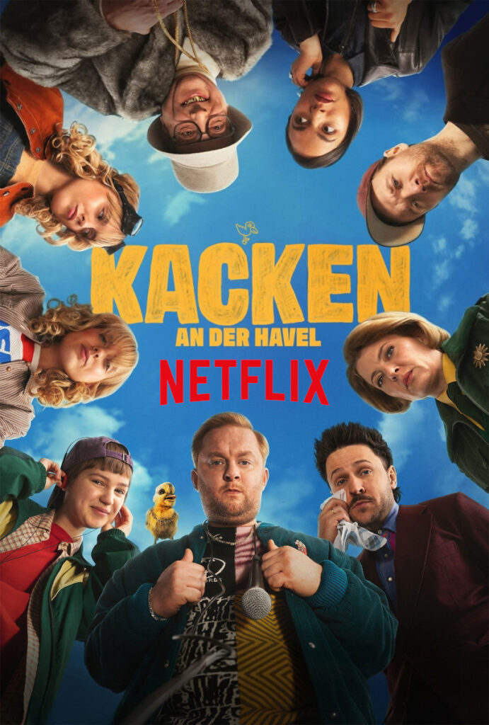 Poster für die Netflix-Serie «Kacken an der Havel». Acht Personen bilden einen Kreis und schauen von oben in die Kamera, vor blauem Himmel mit Wolken. In der Mitte steht der gelbe Serientitel und das rote Netflix-Logo. Ein kleiner gelber Vogel ist ebenfalls zu sehen.