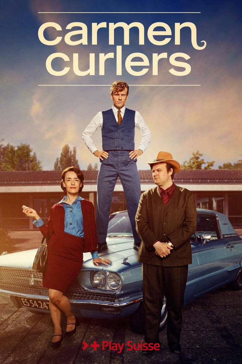 Serienplakat «Carmen Curlers» auf Play Suisse: Drei Personen in 1960er-Jahre-Mode posieren vor einem hellblauen Oldtimer. Ein Mann steht auf der Motorhaube, flankiert von einer Frau und einem Mann mit Cowboyhut.