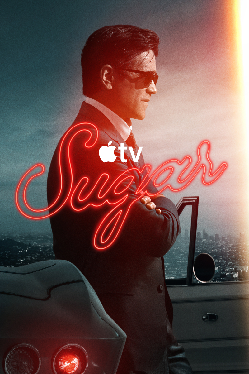 **Alt-Text:** Poster der Apple-TV-Serie «Sugar»: Ein Mann im dunklen Anzug und Sonnenbrille lehnt mit verschränkten Armen an einem Auto. Im Hintergrund eine Stadtansicht. Der Serientitel leuchtet in roter Neonschrift.